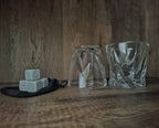 Gedraaide glazen voor whisky met ijsstenen voor een verfijnde drinkervaring.